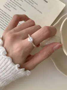 Primer plano de un anillo de plata S925 con circón giratorio en un dedo femenino