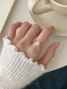 Detalle de un anillo giratorio S925 de plata dorada con circón usado en un dedo