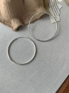 Nahaufnahme von silbernen Creolen Ohrringen in minimalistischem, dünnem Design