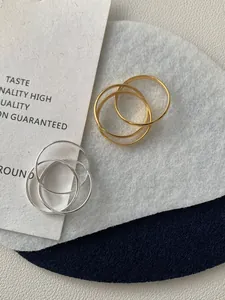 Dettaglio di anelli Trinity intrecciati in argento S925 con finitura oro e argento