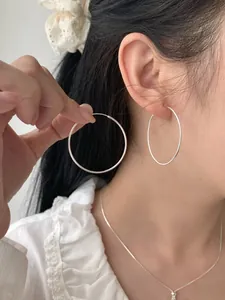 Nahaufnahme von Model mit großen polierten S925 Silber-Creolen im minimalistischen Design