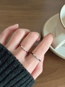 Anelli minimalisti in corda intrecciata rossa e nera con perle d'argento sulla mano