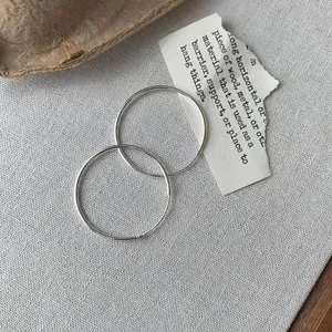 Minimalistische Creolen aus S925 Sterlingsilber auf natürlichem, texturiertem Grund