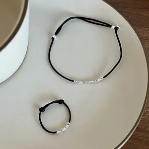 Set minimalista di bracciale e anello in argento S925 con cordino nero in un piatto