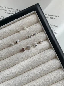 Vista de detalle de pendientes geométricos de plata de ley S925 en una bandeja de joyería