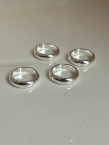 Dettaglio macro degli anelli minimalisti in argento S925 lucido con marchio di autenticità
