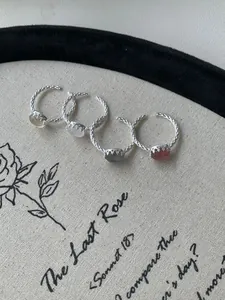Dettaglio di quattro anelli in argento S925 con cristalli ovali colorati e trama a corda
