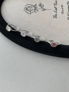 Dettaglio di quattro anelli in argento S925 con cristalli ovali e fasce intrecciate