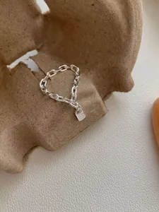 Macro-opname van de S925 zilveren kettingring met een gedetailleerde mini-slot hanger