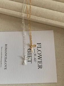 Macro detail of silver and gold bow pendants with teardrop zircon on elegant gift cards