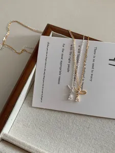 Detail shot of S925 silver bow necklaces with teardrop zircons in gold and silver finish