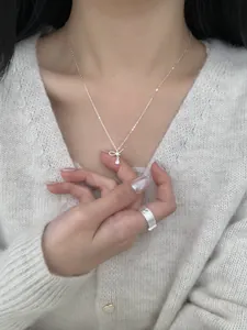 S925 silver bow necklace with zircon drop and wide textured ring on model