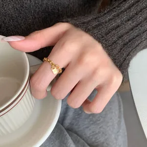 S925 sterling zilveren gouden kettingring met slot hanger gedragen bij een kopje koffie