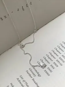 Detail der S925 Sterlingsilber Chopin-Halskette mit verstellbarem Schieber auf Vintage-Buch
