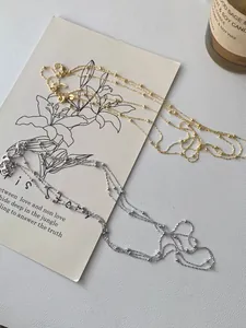 Details von gold- und silberfarbenen Perlenketten auf Kunstkarten mit Kerze