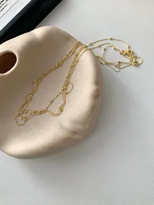 Detail der goldenen Kugelkette mit kleinen Perlen und sicherem Karabinerverschluss