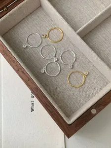 Dettaglio di anelli sottili in argento S925 e oro con ciondoli in zircone lucido