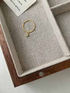 Dettaglio macro anello minimalista in argento S925 dorato con ciondolo in zircone