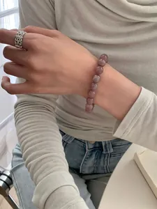 Detail eines Naturamethyst-Perlenarmbands und eines Vintage-Silberrings am Handgelenk