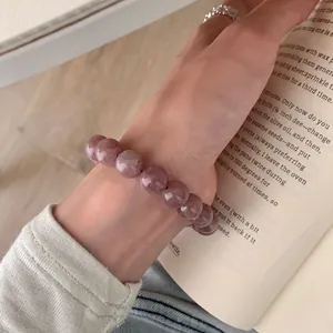 Brasilianisches grau-violettes Naturkristall-Perlenarmband von einem Model getragen