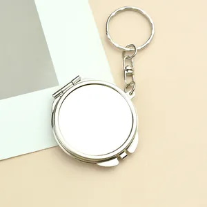 Detail view of the silver metal mini folding mirror keychain with rotating key ring