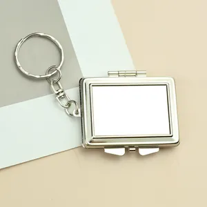 Detail of silver rectangular flip-cover keychain with polished metallic finish and chain