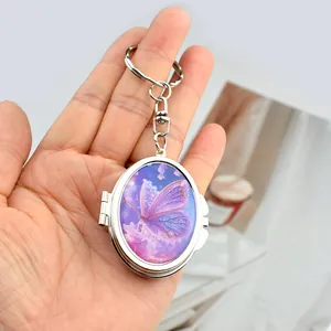 Mini metal oval locket keychain with purple butterfly pattern and flip-open mirror