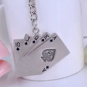 Macro shot of vintage silver poker keychain featuring royal flush spades on white cup