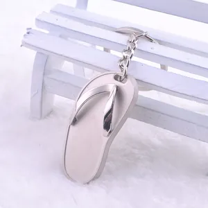 Kreativer Metall-Schlüsselanhänger in Flip-Flop-Form auf einer weißen Bank