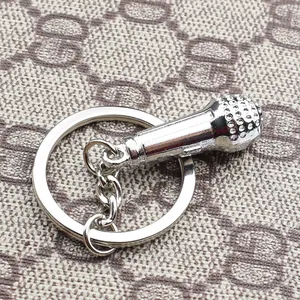 Close-up of a silver microphone keychain with detailed mesh texture and metallic ring