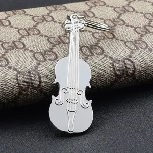 Polished silver violin shaped metal keychain with flat ring on textured background