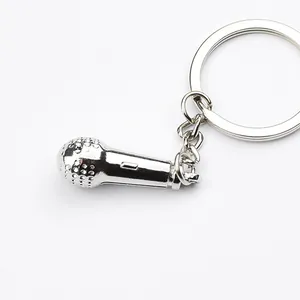 Detail of creative silver metal microphone keychain with realistic mesh texture and ring