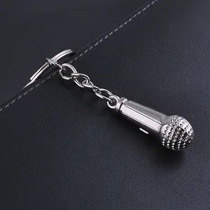 Macro shot of silver metal microphone keychain with textured head and flat ring on leather