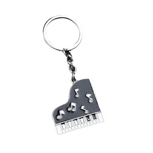 Portachiavi a forma di pianoforte a coda in metallo con note musicali di strass