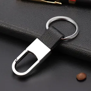 Llavero de cuero negro y metal plateado premium exhibido con accesorios de negocios