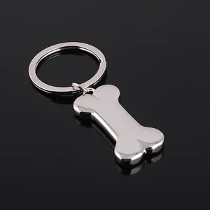 Polierter Metall-Knochen-Schlüsselanhänger in Silber auf schwarzem, glänzendem Hintergrund