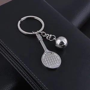 Detail of silver metal tennis racket and ball keychain on premium black leather