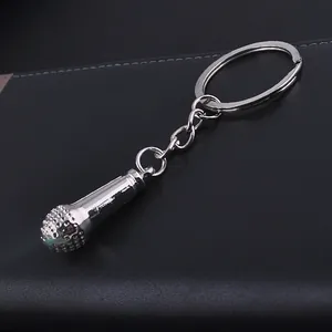 Polished silver microphone keychain made of durable metal on a black textured background