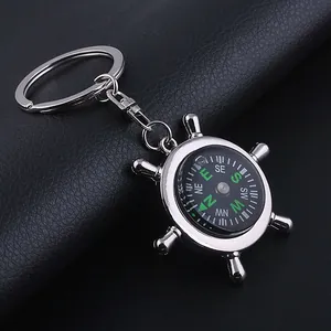 Macro detail of silver zinc alloy helm compass keychain on black leather background
