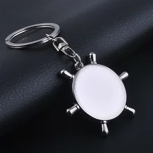 Macro detail of silver nautical helm keychain with white round printable center insert