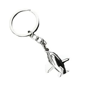 Polished silver metal airplane keychain with minimalist model pendant on white background