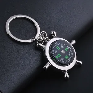 Macro shot of silver helm compass keychain on black leather background
