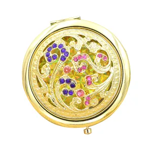 Vintage bronze folding makeup mirror with ornate hollow floral design and crystals