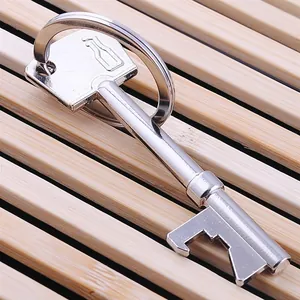 Creative silver key-shaped beer bottle opener with metallic ring on a bamboo mat