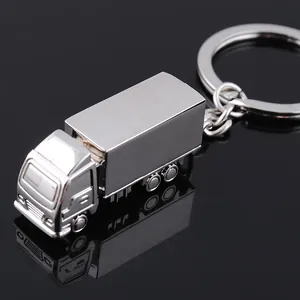 Portachiavi a forma di camion in metallo argento lucido con rimorchio su piano riflettente