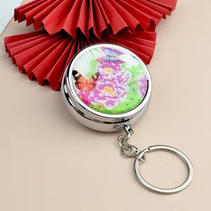 Porte-clés pilulier rond en métal argenté avec motif papillon et pivoine élégant