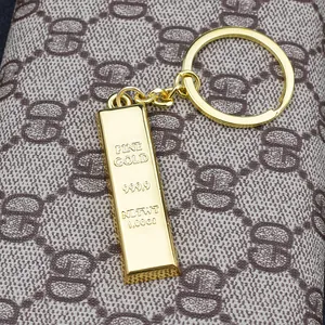 Macro shot of gold bar keychain with fine gold 999.9 engraving on luxury leather