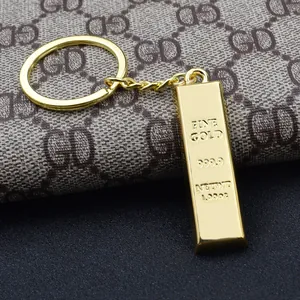 Macro detail of gold bar keychain with 999.9 engraving and polished metallic finish
