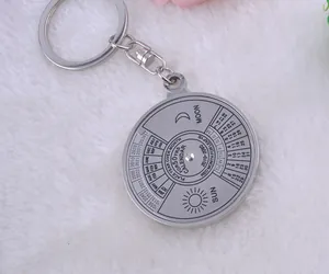 Close-up of a silver 50-year perpetual calendar metal keychain from 2010 to 2060