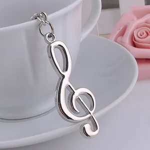 Portachiavi con chiave di violino in metallo argento lucido sul bordo di una tazza